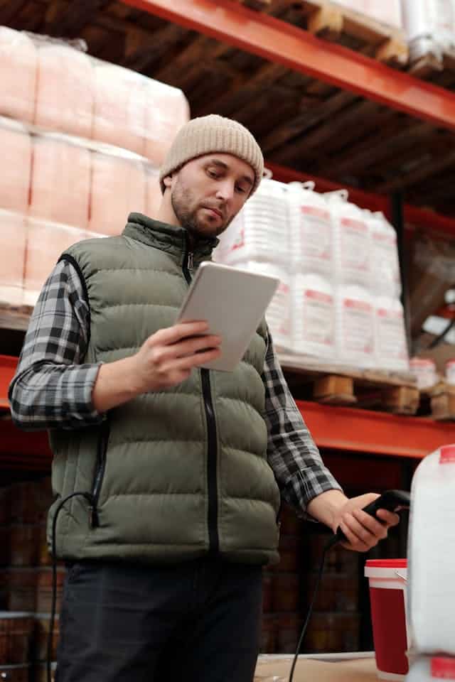 Warehouse worker using a tablet while tracking inventory